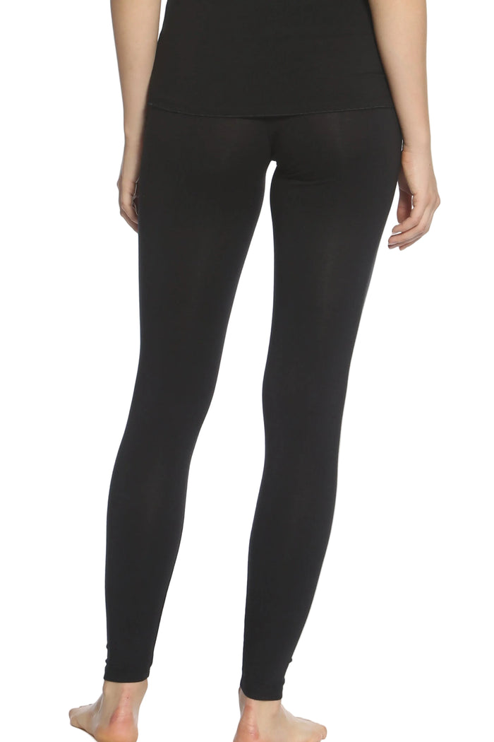 Back view of woman wearing black cotton loungewear leggings, barefoot, on white background