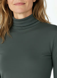 Woman wearing a dark green turtleneck t-shirt on a white background