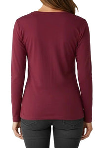 Person wearing a burgundy long-sleeve top and black pants on a white background