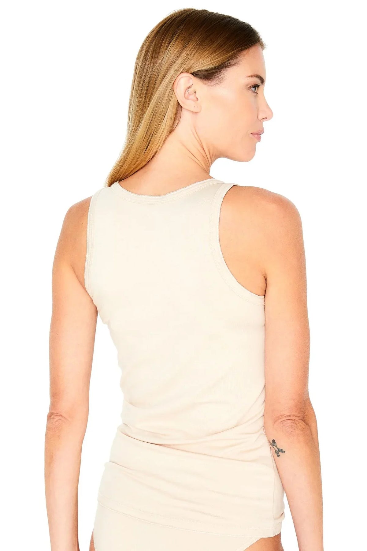 Woman showing back of beige ribbed tank top loungewear, relaxed fit, neutral background