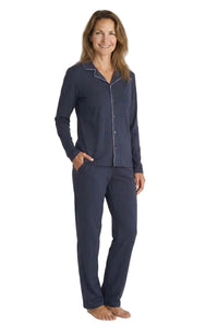 Woman wearing navy blue Pima cotton pajama set with white piping, standing barefoot