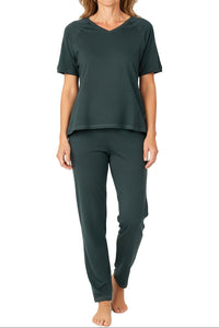 Woman wearing dark green casual short sleeve top and matching pants set on white background