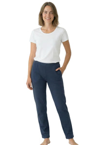 Woman in white short sleeve t-shirt and navy lounge pants, barefoot, on white background