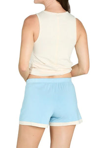 Woman wearing sleeveless cream top and sky blue lounge shorts, back view