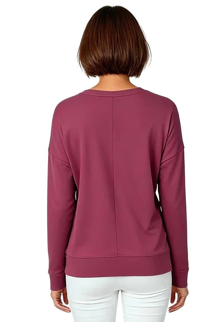 Back view of woman wearing rosewood long sleeve loungewear pullover and white pants
