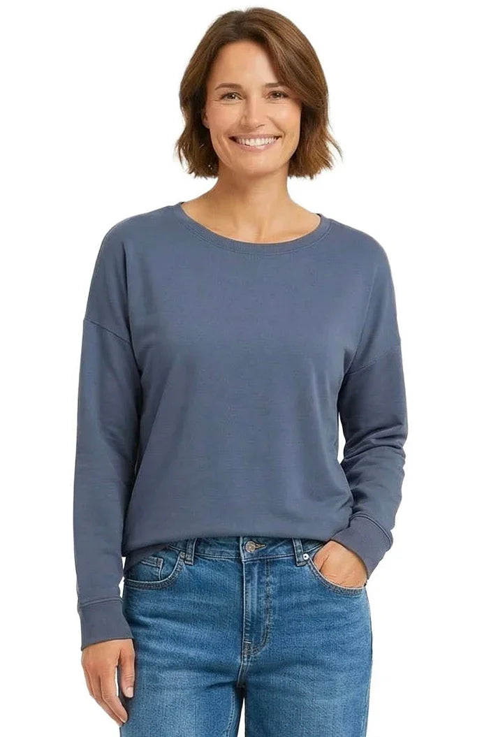 Woman wearing a steel blue long sleeve Pima cotton loungewear top with blue jeans