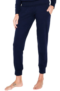 Woman wearing navy blue Pima cotton lounge pants with pockets, bare feet visible