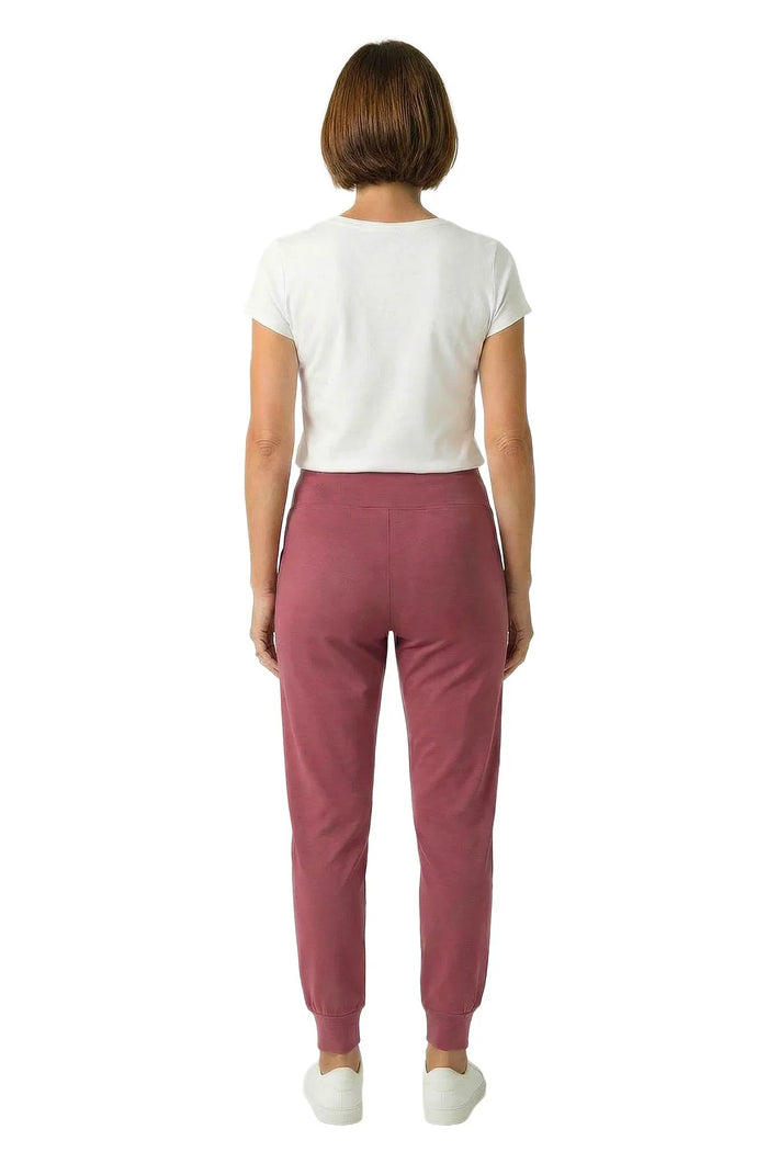 Woman wearing rose pink lounge joggers and white short sleeve tee, back view