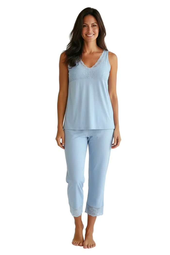 Woman wearing light blue Pima cotton loungewear set with lace trim, standing barefoot