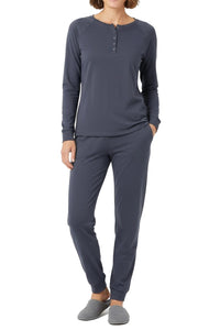 Woman wearing a steel blue long-sleeve henley top and jogger pant set on a white background