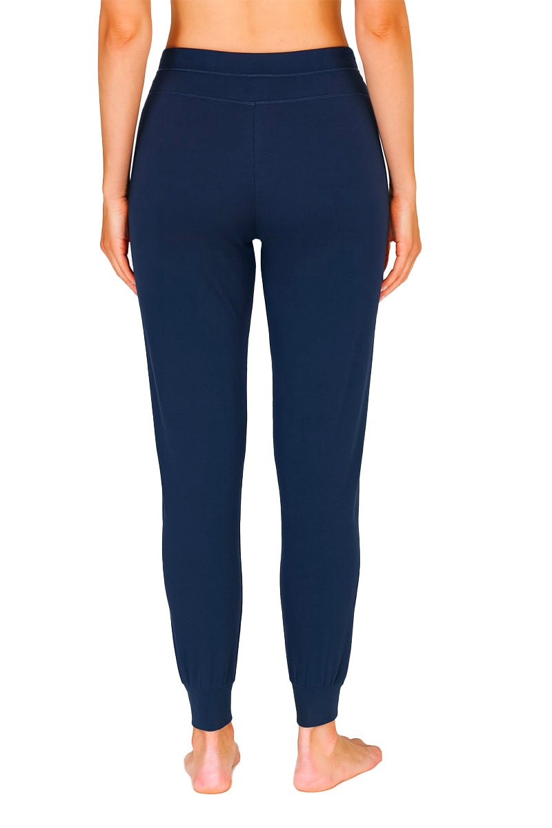 Rearview of navy colored joggers worn by a woman on a white 