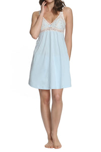 Woman wearing a light blue nightgown with lace details on a white background