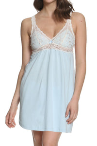 Woman wearing a light blue nightgown with lace details on a white background