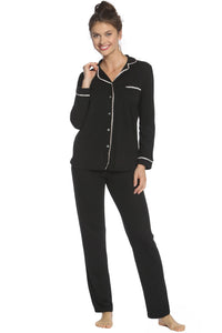 Woman wearing black button-up pajama set with white trim, long sleeves and pants
