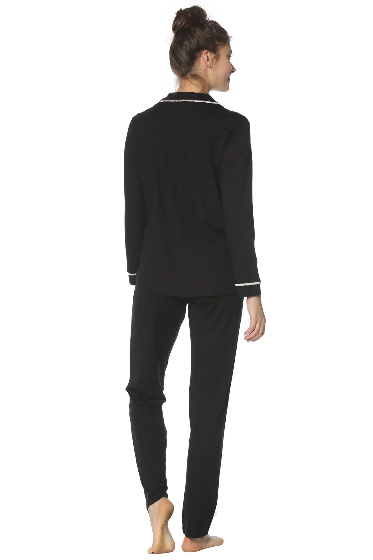 Back view of woman wearing black long sleeve loungewear pajama set with white trim