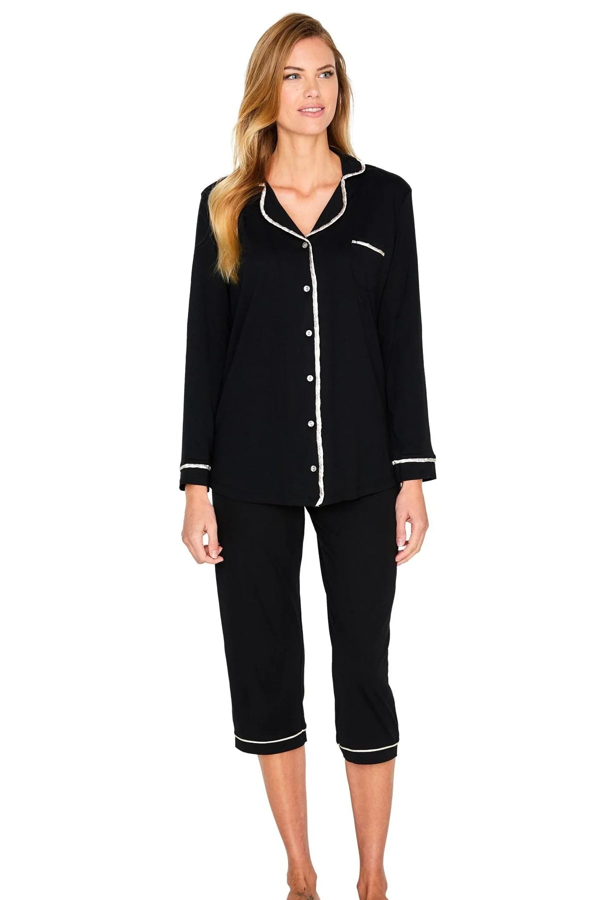 Woman wearing black button-up Pima cotton pajama set with white piping, three-quarter pants.