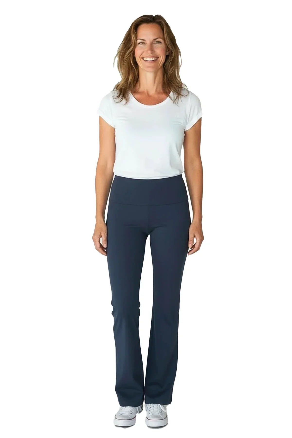 Smiling woman wearing white t-shirt and steel blue yoga pants with sneakers on white background