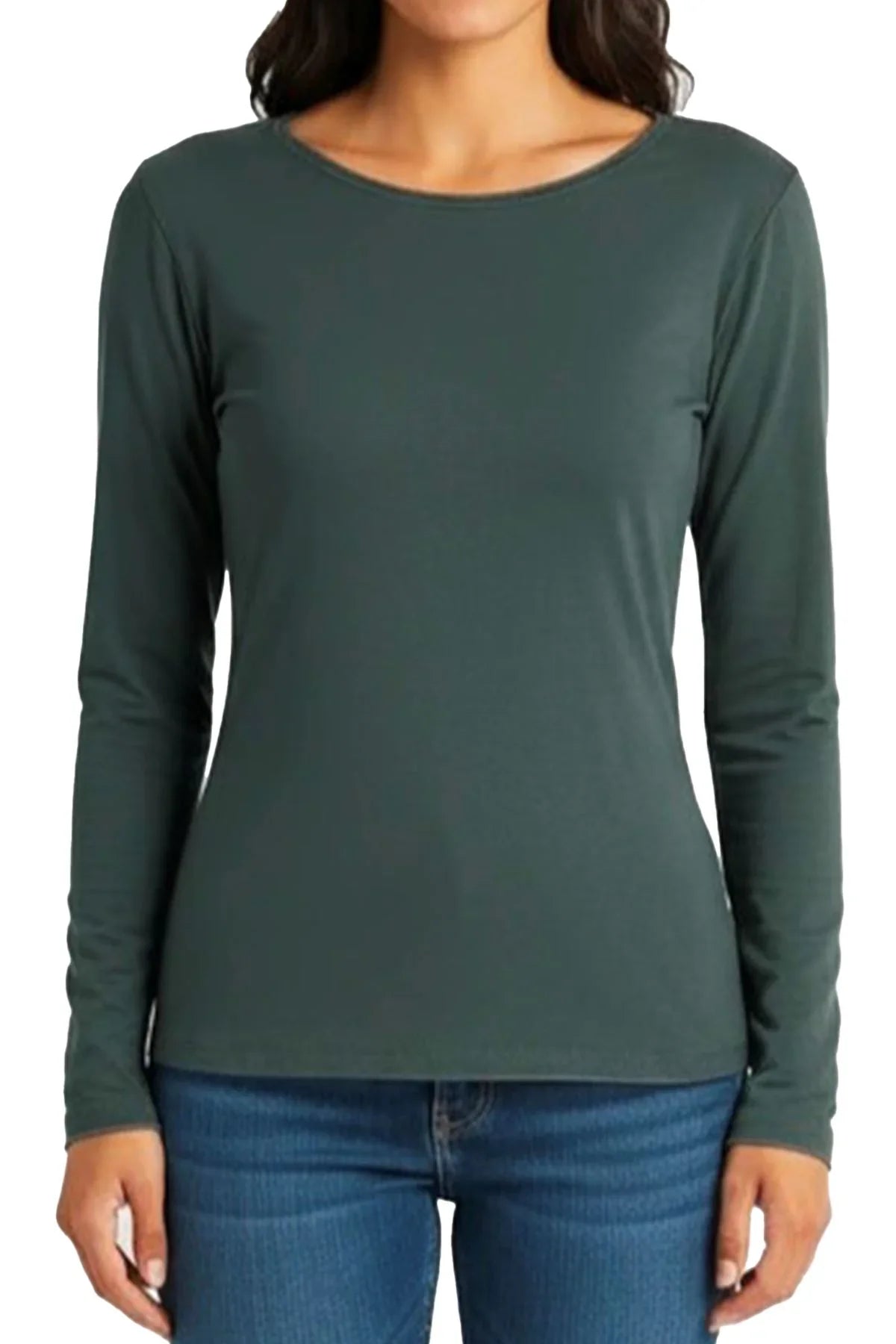 Woman wearing a spruce green long-sleeve fitted shirt paired with blue jeans on white background