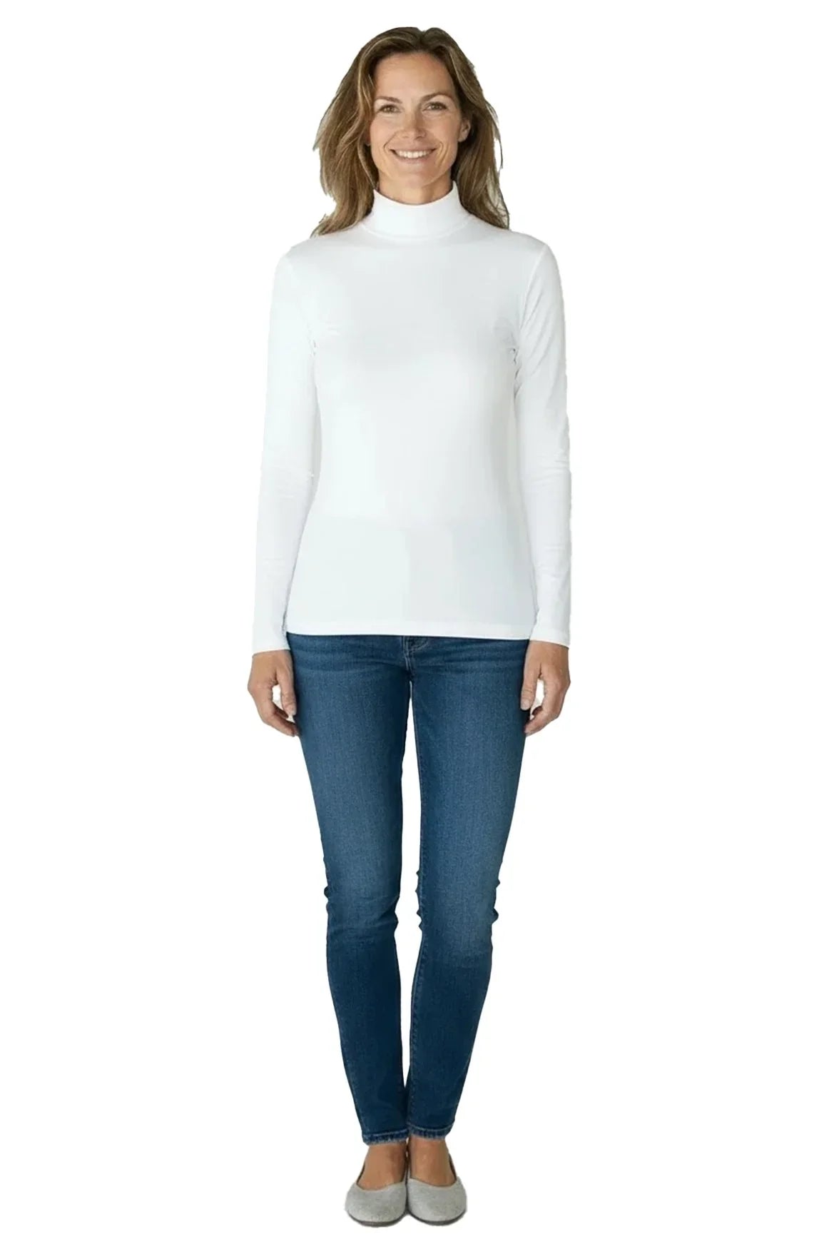Smiling woman wearing white turtleneck long-sleeve shirt with blue jeans and gray flats