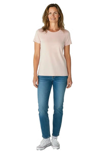 Woman wearing shell pink short sleeve t-shirt with blue jeans and white sneakers on white background