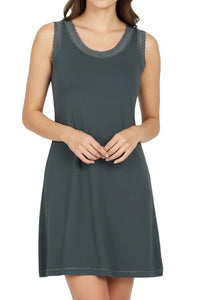 Woman wearing sleeveless dark green nightdress with lace trim on neckline and armholes