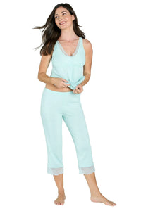 Smiling woman in light blue lace-trim tank camisole and cropped pants pajama set on white background