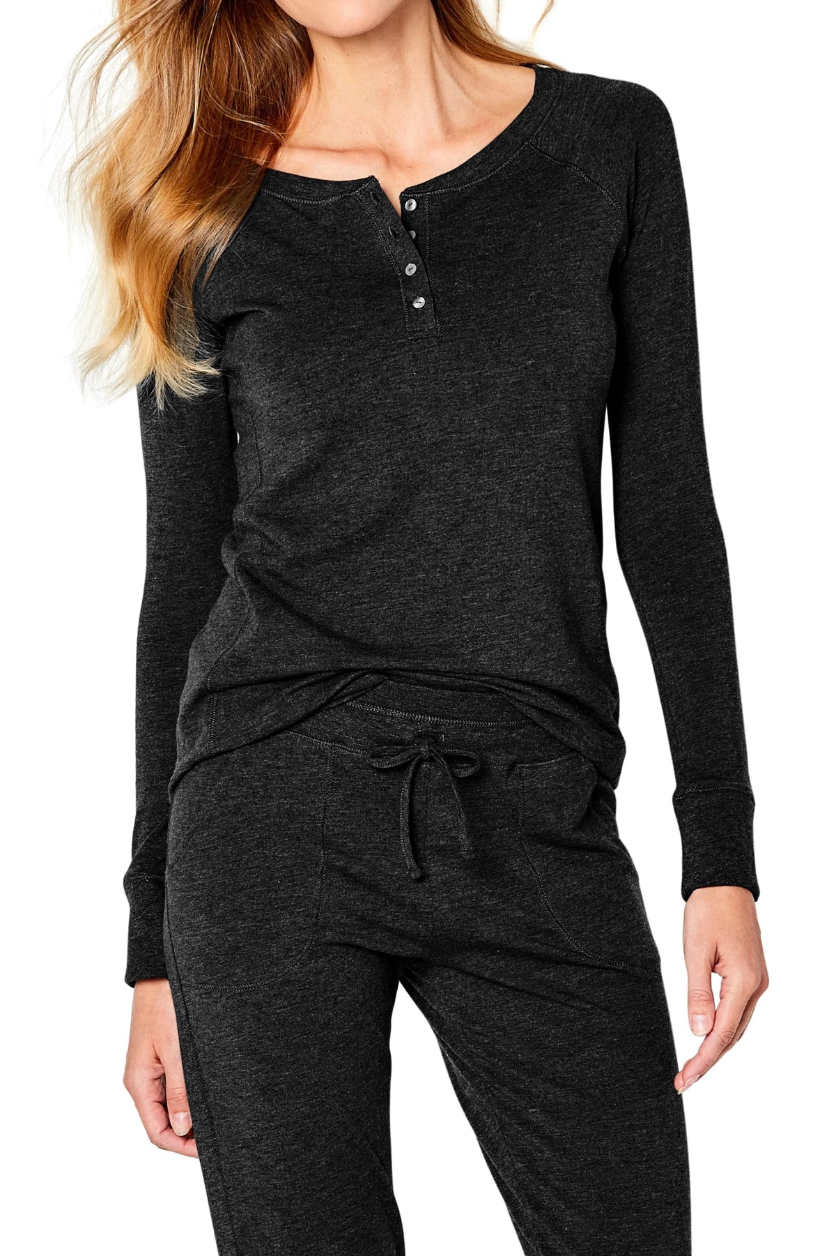 Woman wearing black long-sleeve henley top and matching drawstring pants in casual loungewear