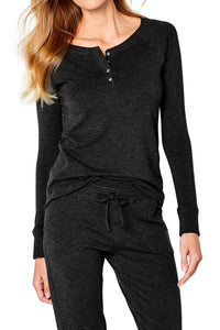 Woman wearing black long-sleeve henley top and matching drawstring pants in casual loungewear
