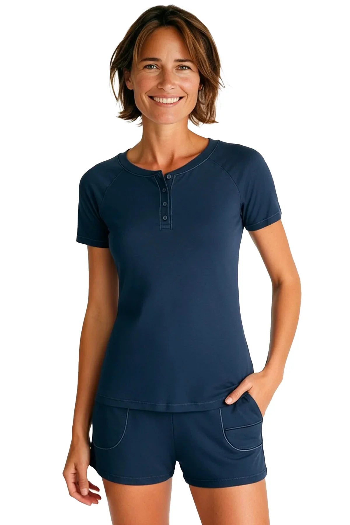 Smiling woman wearing steel blue short sleeve henley top and matching shorts on white background