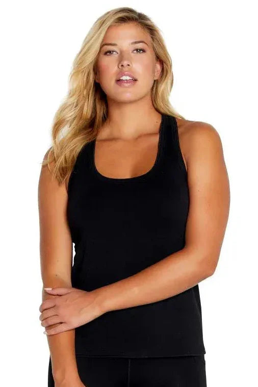Woman in black racerback tank top and black leggings, relaxed loungewear style